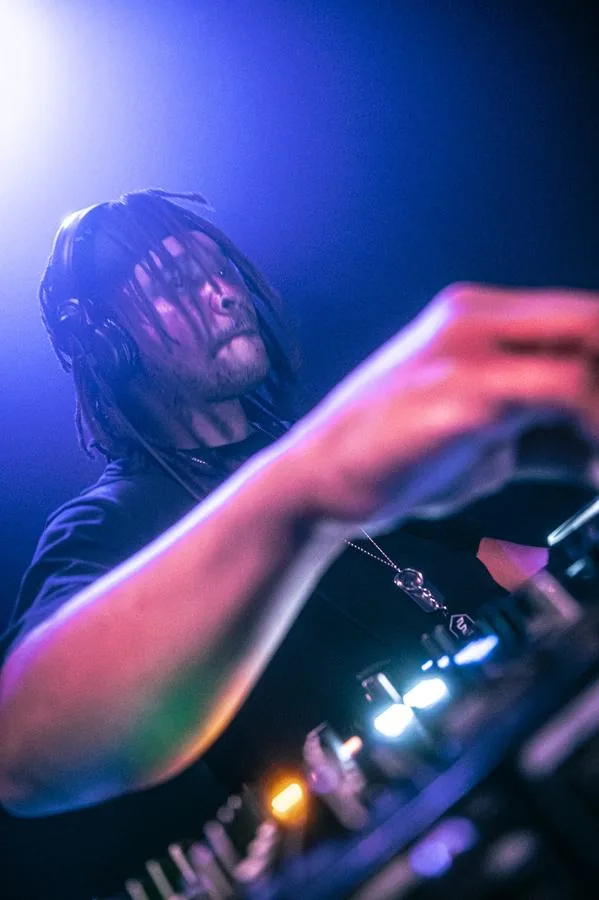 Quentin Hiatus on the decks, close-up under blue stage light